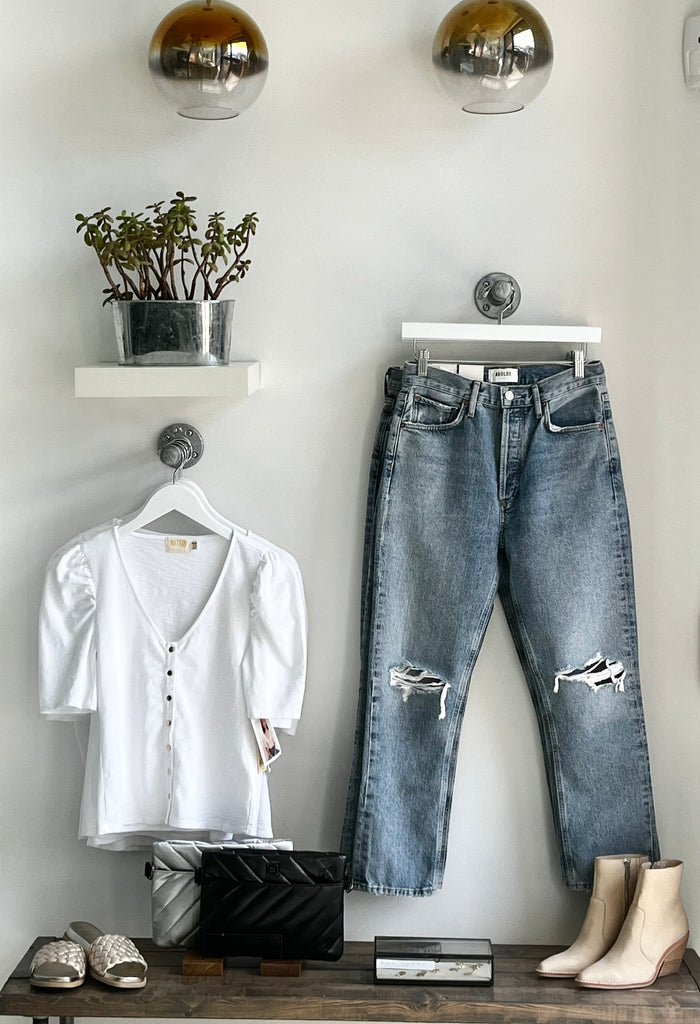 Wall display at Jean Theory: featuring a white blouse and distressed blue jeans